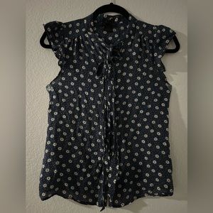 Navy blue blouse with beige flowers and orange dots.